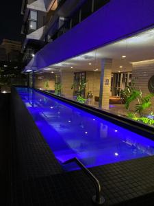 uma grande piscina com luzes azuis num edifício em VN Oscar Freire - O Melhor de Pinheiros em São Paulo
