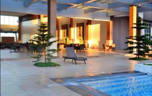a hotel lobby with a pool and tables and chairs at Dan's Cool Suites Tagaytay in Tagaytay