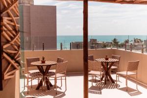a patio with two tables and chairs on a balcony at Conde Hotel Maceió in Maceió +38 photos