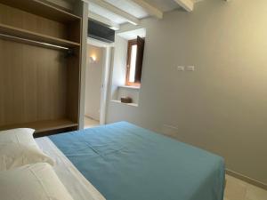 Un dormitorio con una cama con una manta azul. en Il Ginepro en Vico nel Lazio