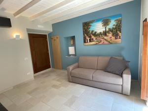 een woonkamer met een bank en een schilderij aan de muur bij Il Ginepro in Vico nel Lazio