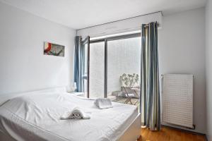 a bedroom with a white bed and a window at Superb apartment with parking & terrace in Bordeaux center - Welkeys in Bordeaux