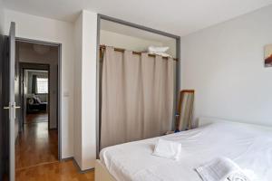 a bedroom with a white bed and a sliding door at Superb apartment with parking & terrace in Bordeaux center - Welkeys in Bordeaux