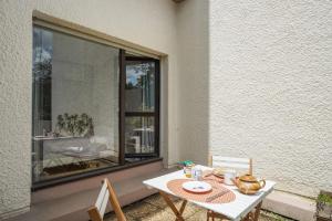 a table and chairs on a patio with a window at Appartement des Sablières - Welkeys in Bordeaux