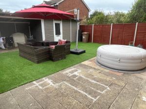 a backyard with an umbrella and a chair and a table at ANGIE HOME in Luton