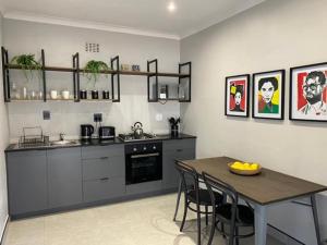 eine Küche mit einem Tisch, einem Tisch und Stühlen in der Unterkunft 46 on Allcock Guest Apartment & Luxury Room in Pretoria