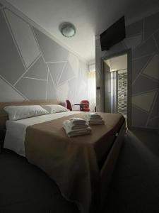 ein Schlafzimmer mit einem Bett mit Handtüchern darauf in der Unterkunft B&B The King in Acconia