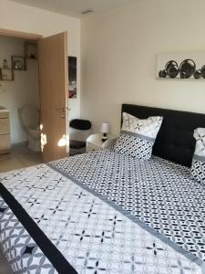 een slaapkamer met een bed met een zwart-wit dekbed bij Les Lauriers in Espondeilhan