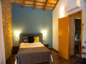 a bedroom with a bed and a blue wall at Mas Masdeu in L'Aldea