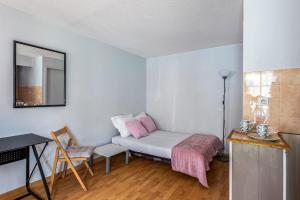ein kleines Zimmer mit einem Bett und einem Spiegel in der Unterkunft Studio Flamant - Welkeys in La Rochelle