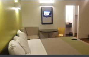 una camera d'albergo con letto e TV di American Inn a Hawthorne