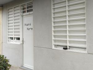 une fenêtre avec un panneau sur le côté du bâtiment dans l'établissement Apartamento Madrid Norte, à Madrid