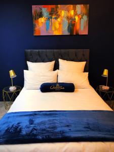 sypialnia z dużym białym łóżkiem z obrazem na ścianie w obiekcie Queen Julie Lodge w Kapsztadzie