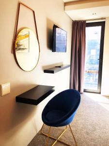 Pokój z niebieskim krzesłem i lustrem w obiekcie Queen Julie Lodge w Kapsztadzie