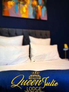 a bed with a queens cubic lodge sign on it at Queen Julie Lodge in Cape Town