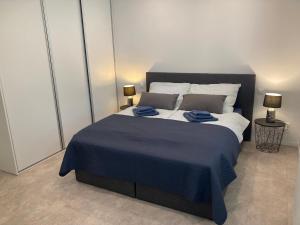 1 dormitorio con 1 cama grande con manta azul en Apartman Duna en Piešťany