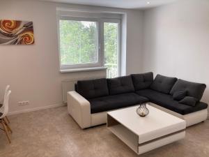 a living room with a black couch and a table at Apartman Duna in Piešťany