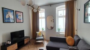 - un salon avec un canapé et une télévision dans l'établissement Kurkowa Apartment, à Wrocław