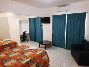 Habitación de hotel con 2 camas y sofá en HOTEL ACUARIO CATEMACO en Catemaco