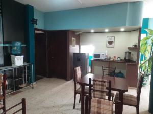 a dining room with a table and chairs and a kitchen at HOTEL ACUARIO CATEMACO in Catemaco