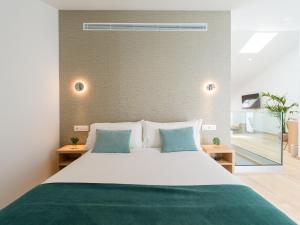a bedroom with a large white bed with blue pillows at Hotel Emeté & Coworking in Las Palmas de Gran Canaria