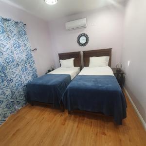 two beds in a room with wooden floors at de Felice in Mount Pleasant