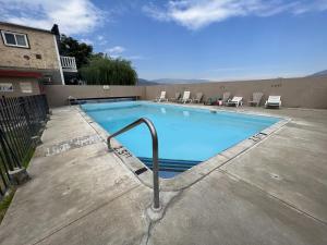 a large swimming pool with a metal hand rail next to a building at Falcon Resort in Osoyoos