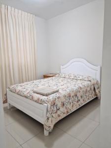 a bedroom with a white bed with a blanket on it at CASA - Mary Ann's House in Trujillo