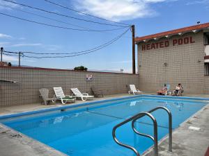 uma piscina em frente a um edifício de piscina aquecida em Spanish Fiesta Resort em Osoyoos