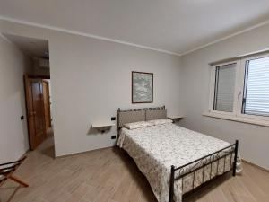 1 dormitorio con cama y ventana en Il Poggio degli Antichi Sapori - Residence, en Paternopoli