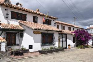 Casa blanca con techo rojo y ventanas en Reserva del Dorado, en Sesquilé