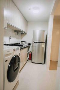 a kitchen with a stainless steel refrigerator and a stove at Work-friendly Mountain-view condo near SM Seaside in Cebu City