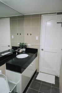 a bathroom with a black counter and a white sink at Work-friendly Mountain-view condo near SM Seaside in Cebu City
