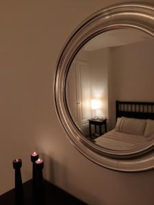 a mirror in a bedroom with a bed and a table at Coto Real Resort in Manilva