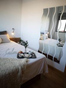 a hotel room with a bed with a tray of food on it at Ático Love in Jerez de la Frontera