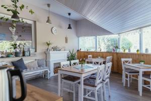 a restaurant with tables and chairs and a couch at Pihi Vendégház in Badacsonytomaj