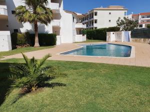 una piscina en un patio con una palmera en BeGuest Areias Apartment, en Albufeira