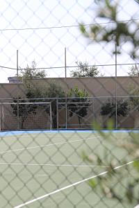 a tennis court with a net in front of a building at Hotel Villa Pascucci in Durrës