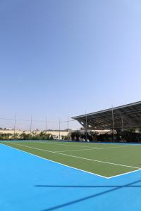 a tennis court with a tennis player on the court at Hotel Villa Pascucci in Durrës