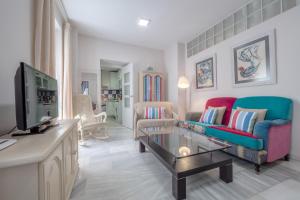 a living room with a couch and a tv at SunShine Templo Romano in Córdoba