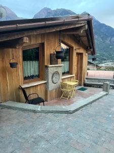 Cabaña de madera con mesa y sillas en el patio en profumo di legno, en Aosta