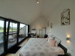 een slaapkamer met een bed en een balkon bij B&B De Stuifduinen in Wetteren
