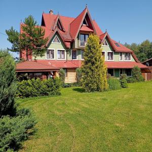 a large house with a red roof on a yard at Kazkowa Koliba in Zakopane