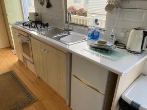 a kitchen with a sink and a counter top at Summer Breeze Caravan in Bacton