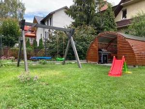 un patio con parque infantil y equipo de juegos en Apartamenty Długa, en Nowy Targ