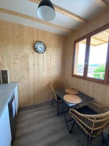 a room with a table and chairs and a clock on the wall at Nuit’s Féerique en Champagne in Meurville