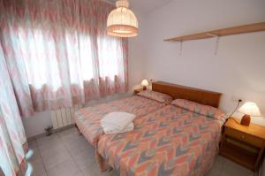 a bedroom with a bed and a desk and a window at Apartamentos Siglo XXI - Ancla in Sant Feliu de Guixols