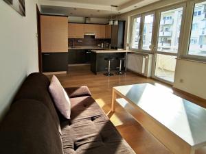 a living room with a couch and a table at Apartament F&J #12 in Toruń