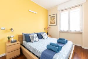 um quarto com uma cama com almofadas azuis em Rosselli 13 Milan Apartment em Milão
