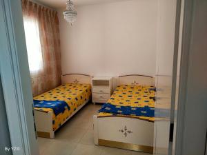 2 Einzelbetten in einem Zimmer mit Fenster in der Unterkunft Appartement Standing Nabeul in Beni Khiar